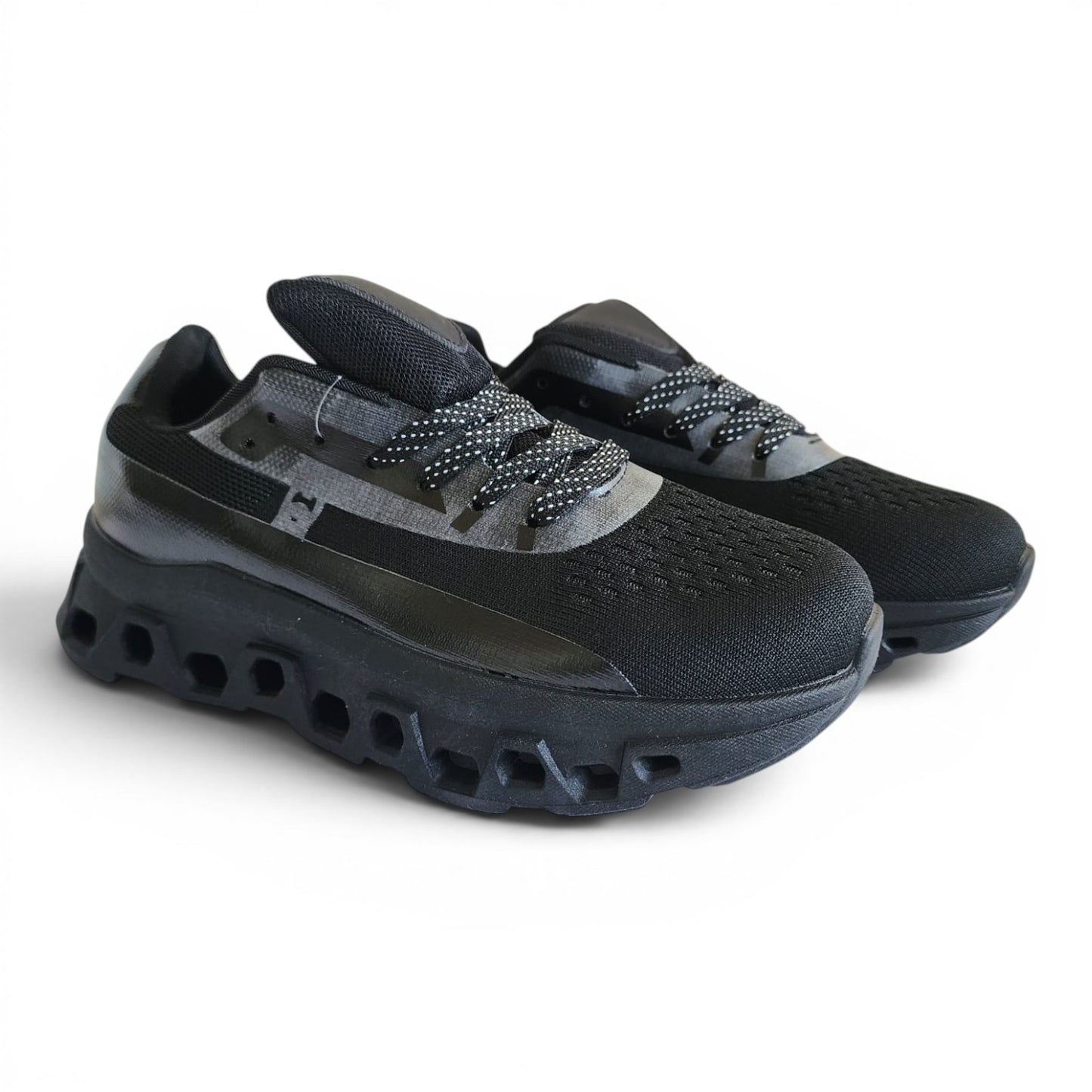 BRIKLYN black athletic running sneakers with breathable knit upper and architectural geometric midsole design.