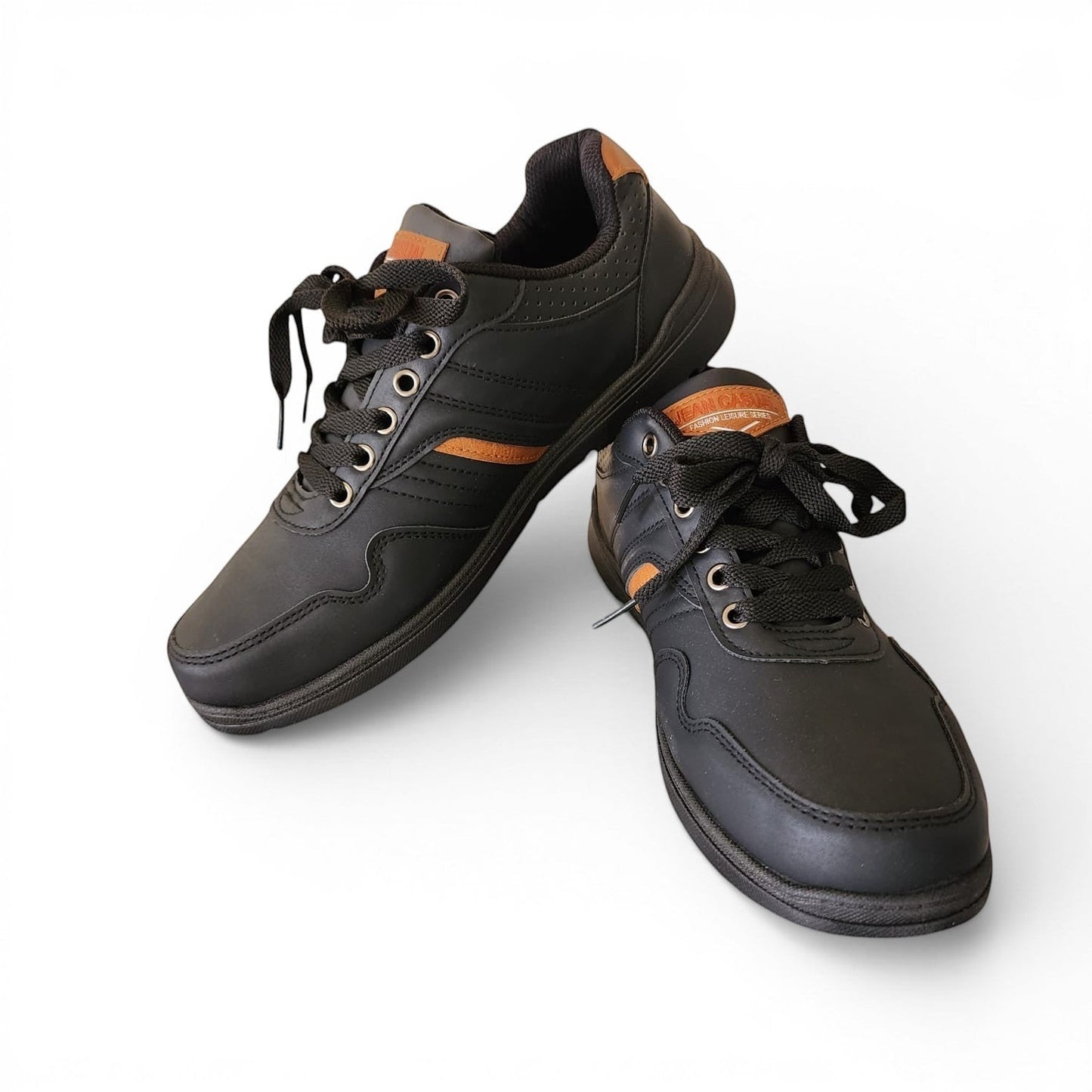 BRIKLYN black faux leather athletic sneakers with tan accents, lace-up closure, and perforated detailing.